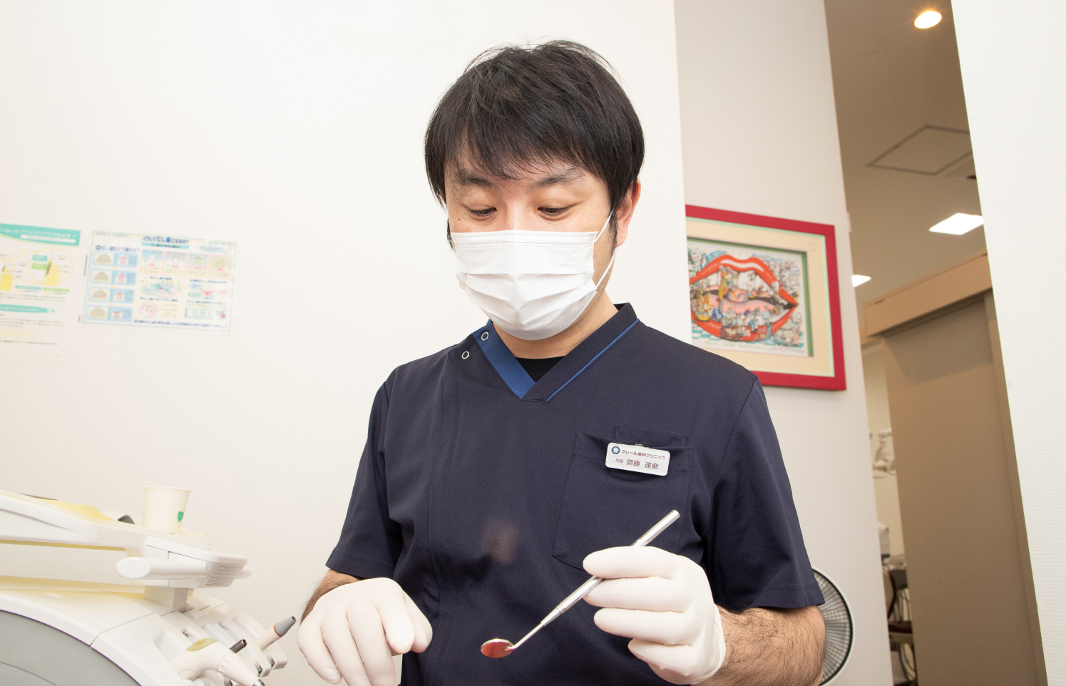 院長が診療器具を手に治療の準備をしている様子